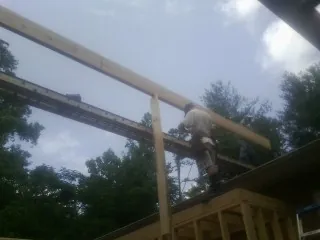 Carpenter setting a ridge beam over a new addition frame — Ice Dam Removal by Roofing Brothers in Somonauk