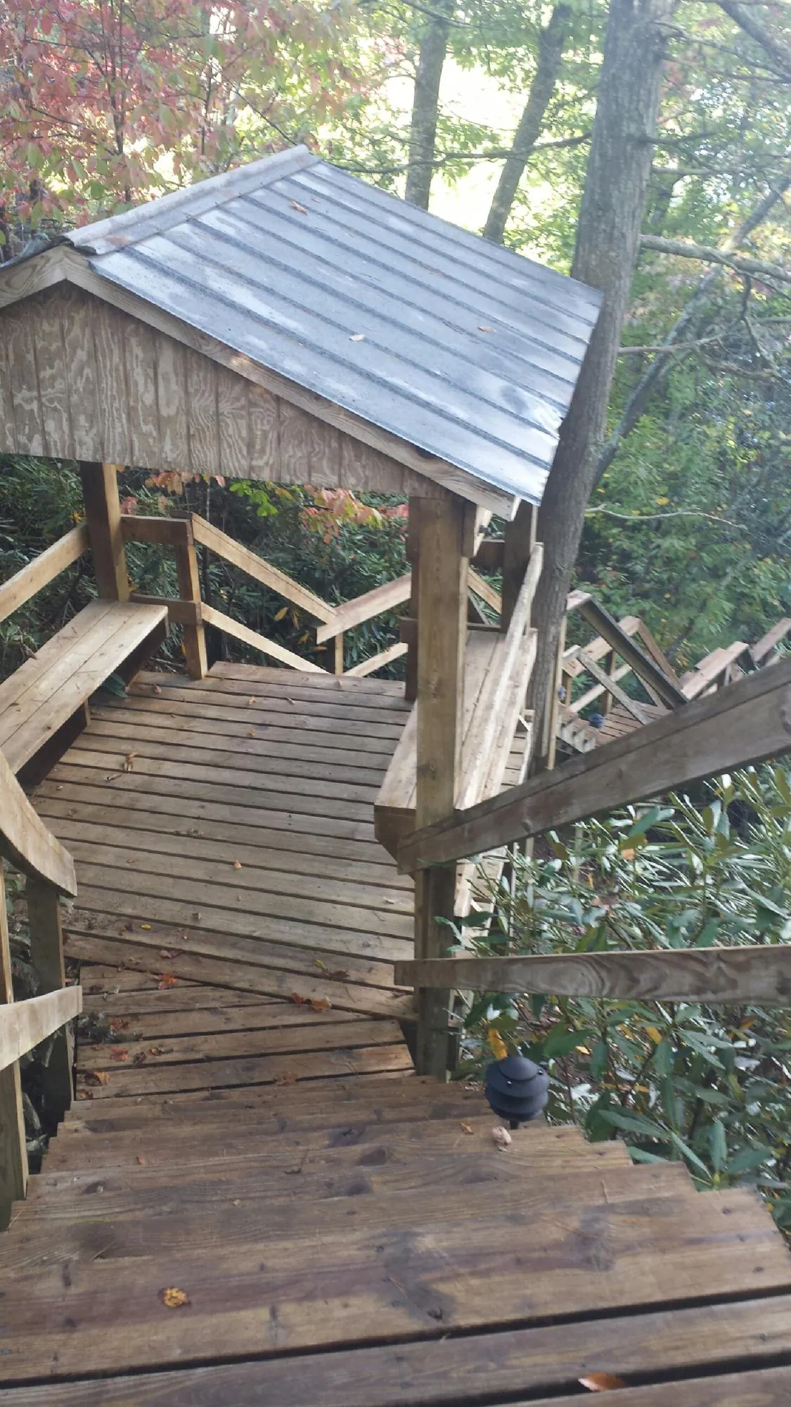 Metal roofed shelter over wooden steps on a wooded walkway — Skylight Repair & Installation work by our crew in Somonauk