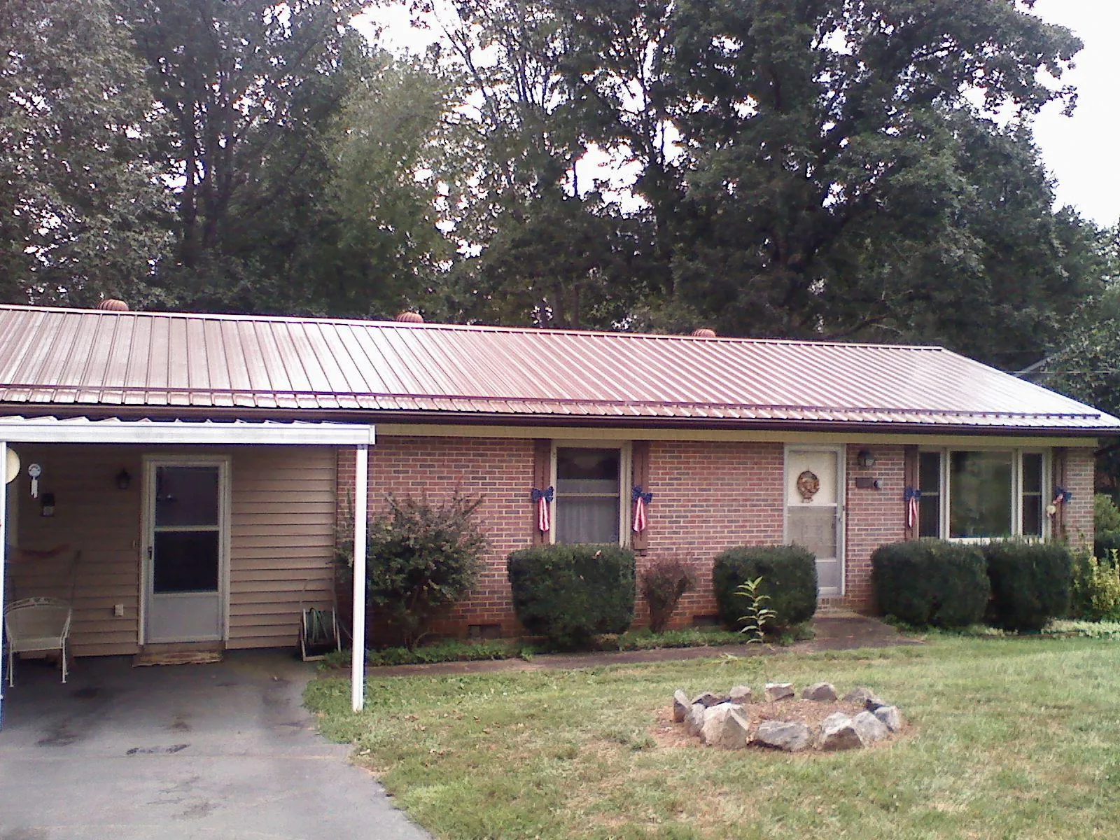 Bronze metal roof and carport on a brick ranch home — Roof Repair work by our crew in Somonauk